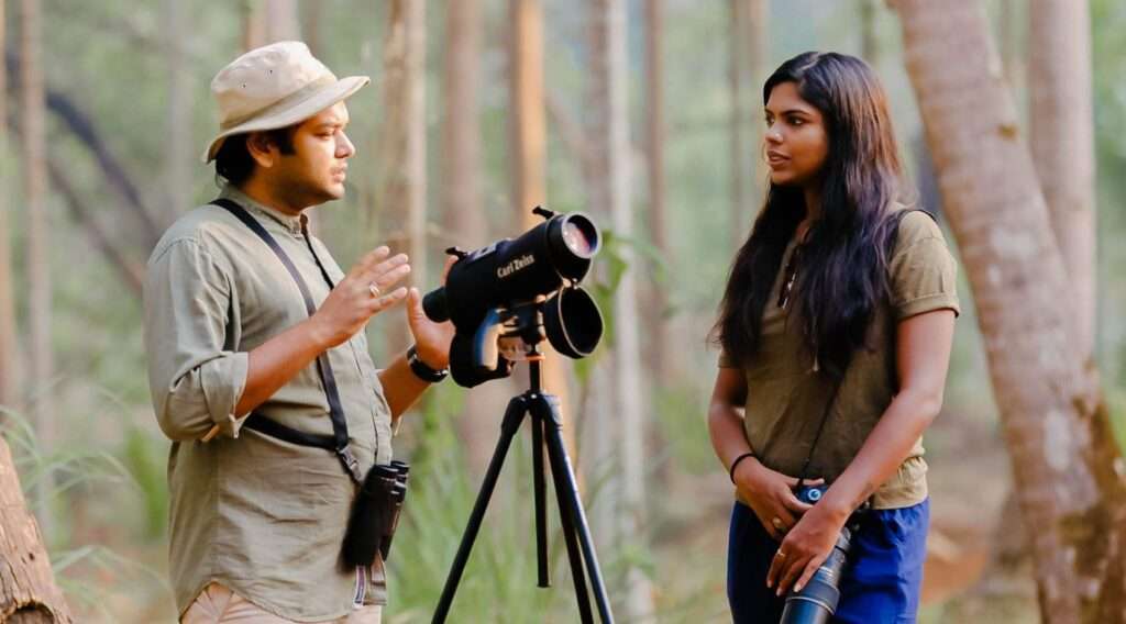 Family enjoying a guided bird watching tour at a beautiful location near a family resort in Goa, surrounded by greenery and diverse bird species