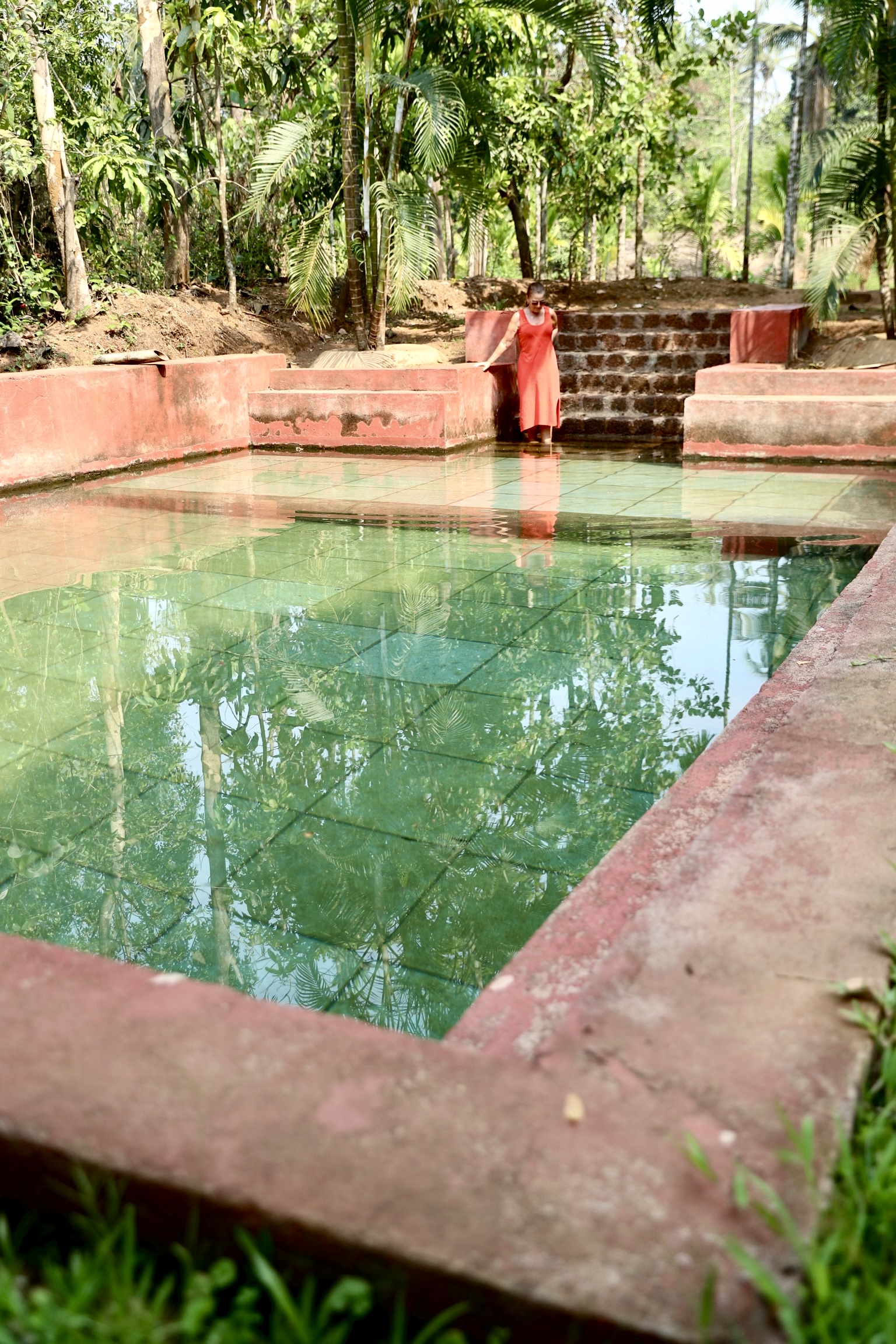 The natural spring pool, still as a mirror